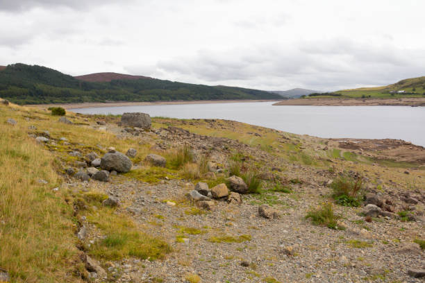 Dry reservoir, affected by water shortage due to increased temperature and lack of rainfall in rural Wales, climate change taking a toll and hosepipe bans being enforced and precious water being very limited. el embalse seco, afectado por la escasez de agua debido al aumento de la temperatura y la falta de lluvias en las zonas rurales de gales, el cambio climático está pasando factura y las prohibiciones de mangueras se aplican y el agua preciosa es muy limit