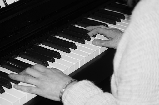 A shot of a lady playing the piano