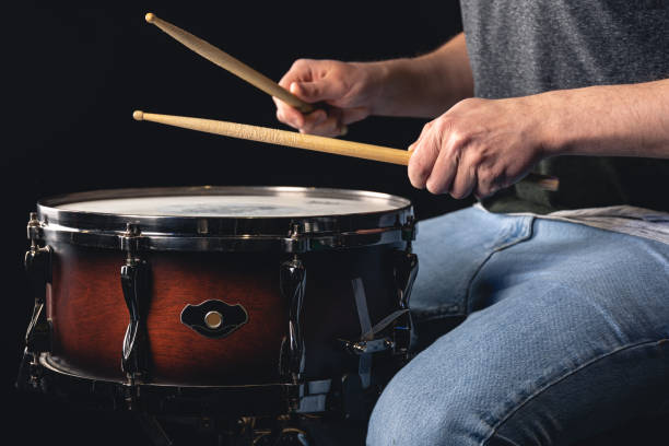 istock A man plays the snare drum against a dark background. 1484916539