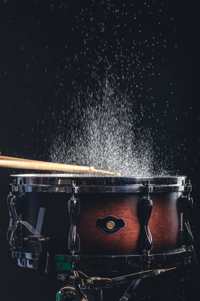 istock Drummer using drum sticks hitting snare drum with splashing water. 1484916547