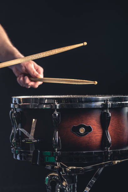 istock A man plays the snare drum against a dark background. 1484916556