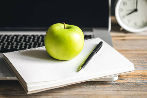 istock Apple near laptop at workplace, healthy snack. 1484917384