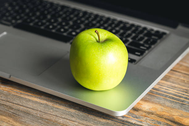 istock Apple near laptop at workplace, healthy snack. 1484917396