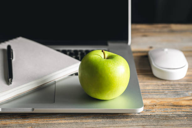 istock Apple near laptop at workplace, healthy snack. 1484917399