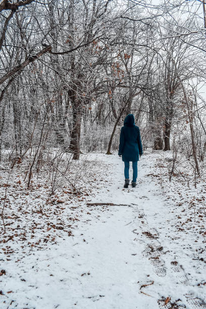 istock A woman walks through a snowy forest 1484918021