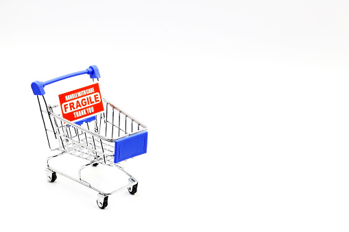 A supermarket trolley with the FRAGILE sign.  Control of household spending, price increases. Inflation