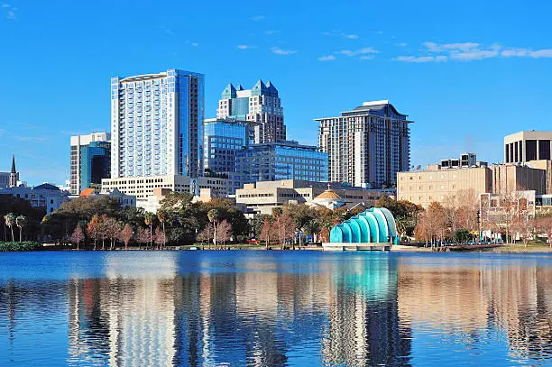 Orlando Lake Eola in the morning with urban skyscrapers and clear blue sky.