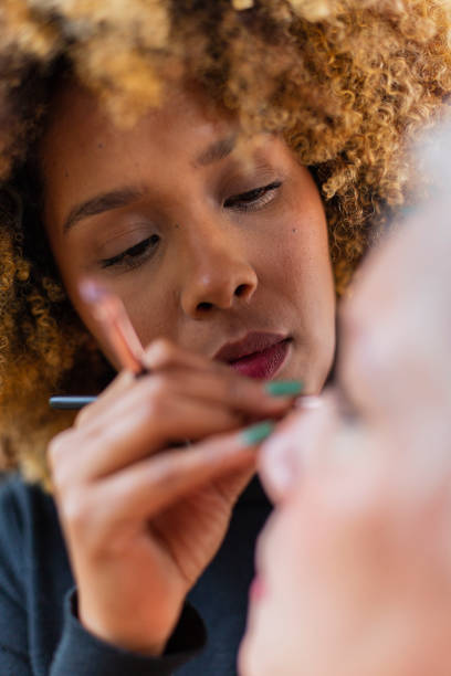 istock Makeup artist performs her work on the model before you start the photo studio 1484930657