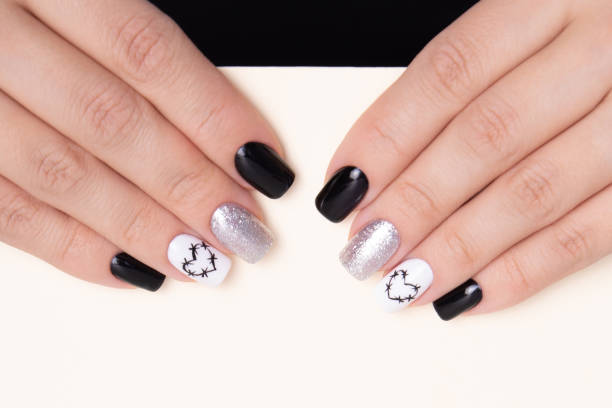 istock Female hands with black manicure nails, hearts design 1484931928