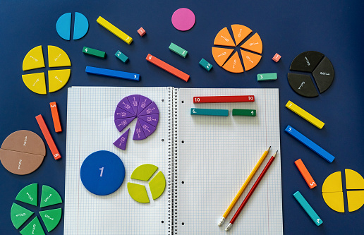 School stationery, fractions, rulers, pencils on magenta background. Back to school, fun education concept. Set of supplies for mathematics and for school. Close up