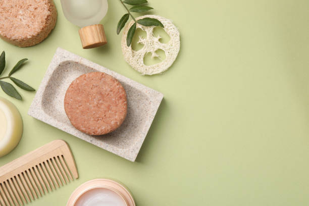 istock Flat lay composition of solid shampoo bars, loofah and comb on green background. Space for text 1484933456