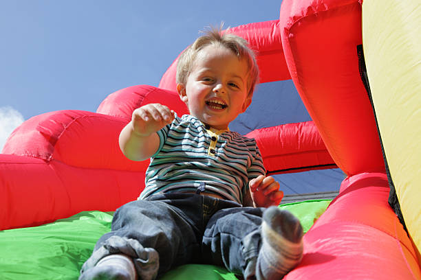 dziecko na dmuchany zamek nadmuchiwane slajdów - inflatable slide sliding child zdjęcia i obrazy z banku zdjęć