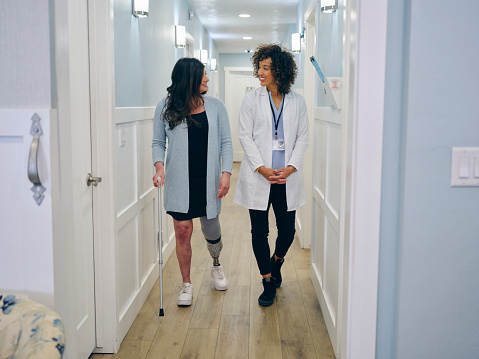 A doctor with her amputee patient, adjusting the patient’s prosthetic limb.