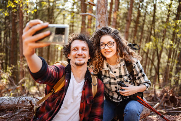 istock Young adventurous couple taking selfies while on a break from hiking in the forest 1484935204