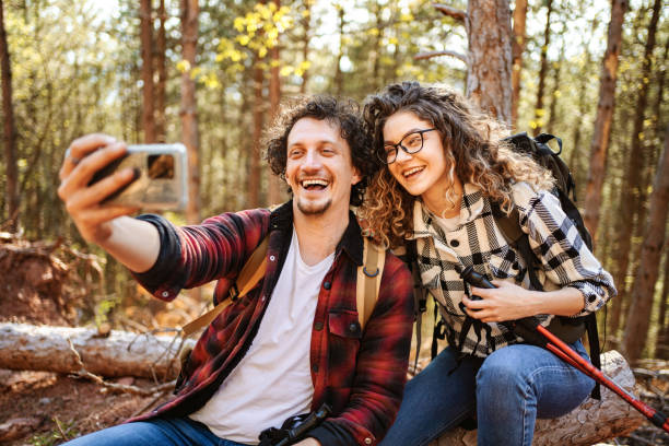 istock Young adventurous couple taking selfies while on a break from hiking in the forest 1484935260