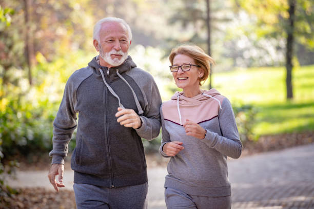 istock Cheerful active senior couple jogging in the park 1484935672