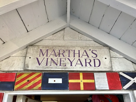 Martha's Vineyard sign on weathered building with dive flags
