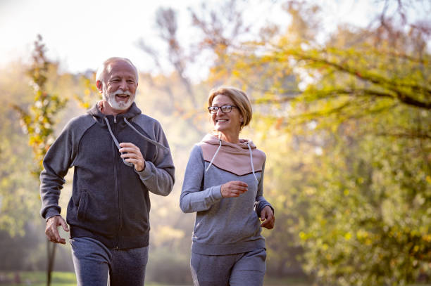 istock Cheerful active senior couple jogging in the park 1484936259