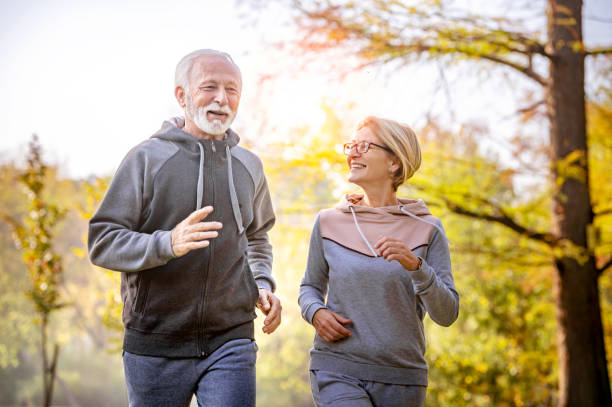 istock Cheerful active senior couple jogging in the park 1484936359