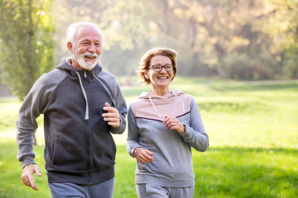 istock Cheerful active senior couple jogging in the park 1484937057