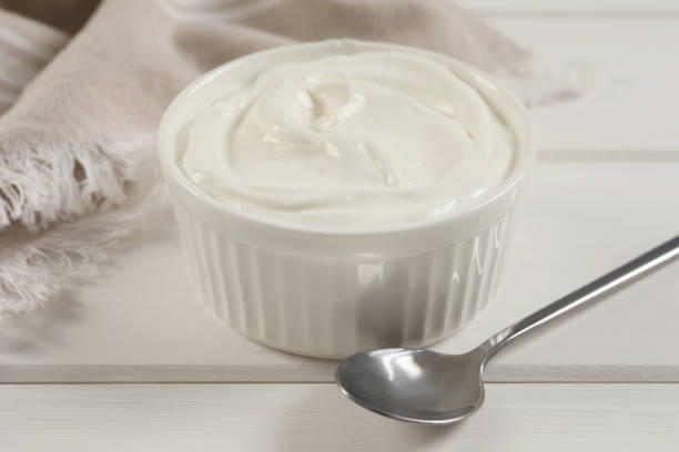 istock Bowl of fresh yogurt on white wooden table 1484937967