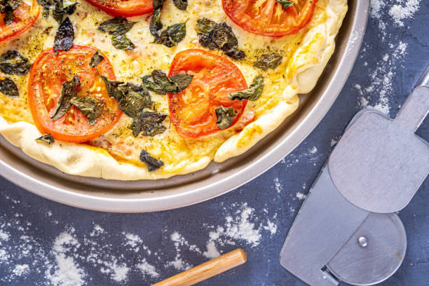 istock Delicious margherita pizza with basil, garlic, tomatoes, eggs. On black background. 1484938650