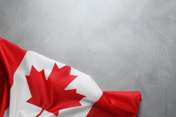 istock Flag of Canada on light grey stone table, top view. Space for text 1484940838