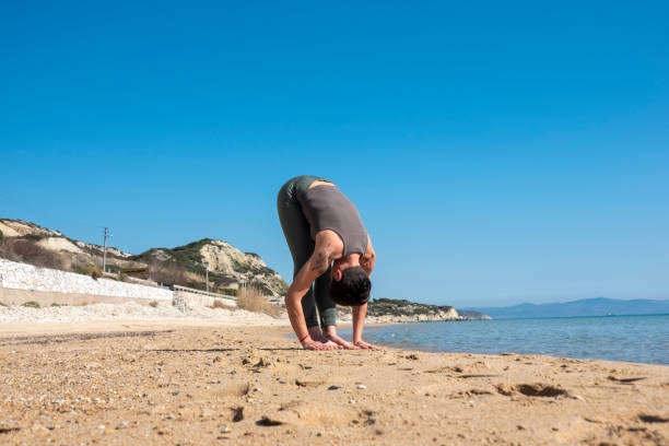 istock Woman practising yoga on the beach 1484943135