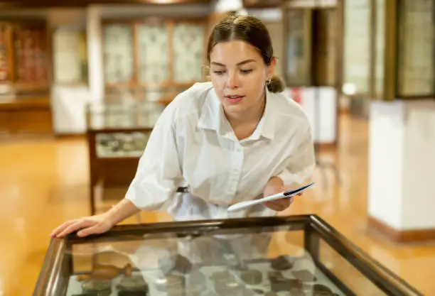 Photo of Young woman with information booklet visiting museum