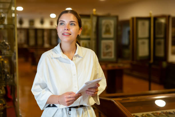 istock Young woman with information booklet visiting museum 1484945706