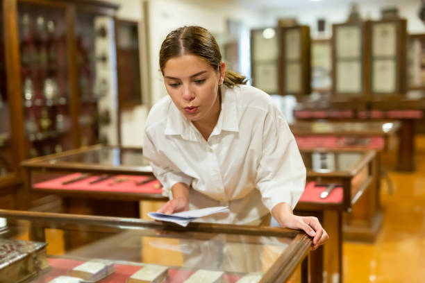 istock Young female looking at the exposition of antique books at museum 1484945708