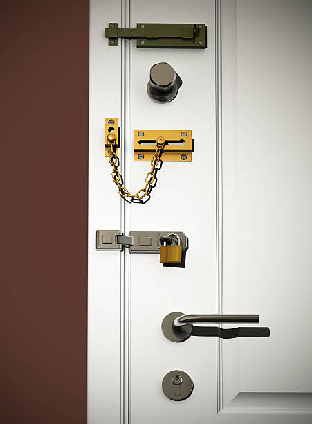 door locks Low angle view on white classic door with several types of DIY safety locks. Scene is lit with a spotlight with small spread for vignetting effect. door chain stock pictures, royalty-free photos & images