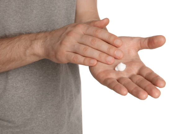 istock Man applying cream onto hand against white background, closeup 1484947713
