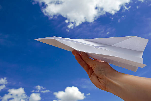 istock Female hand holding paper airplane 148496075