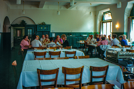 Tourists are enjoying their dine in  Dining Hall of Lyceum Alpinum Zuoz, Switzerland.