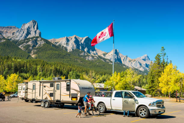 Family gets ready for a bike ride at Nordic Centre Provincial Park in Canmore, Alberta, Canada on a sunny day.