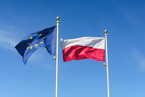 Flag of Poland and the European Union against the sky. EU and Poland concept. High quality photo