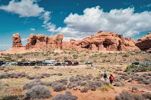 People hike in Arches National Park near Moab, Utah, USA on a sunny day.