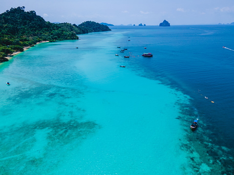 Koh Kradan Island with a white tropical beach and turqouse colored ocean. Drone view from above at a tropical beach