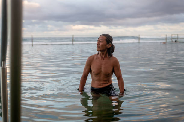 istock Active male swimming in rock pool 1484971303