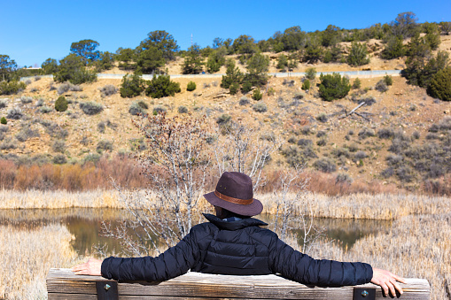 Man in Black Hat Sitting Near Pond, Southwest USA