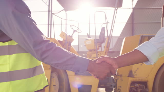 Business people, architect and handshake for deal in construction, partnership or teamwork success on site. Engineer, builder or contractor shaking hands in collaboration for project or architecture