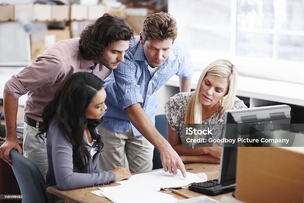 Pointing out a few minor points Three young designers working together in their office and receiving feedback from their boss Adult Stock Photo