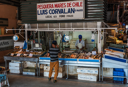 Fish cleaner working at stall on local market of San Agustin