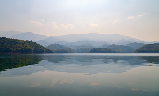 The majestic mountain scenery is reflected in the calm water of Ta Dung Lake, Dak Nong province