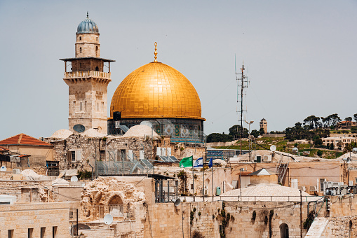 Roof view towards the golden Dome and Minaret of the famous Al-Aqsa Mosque - Qibli Mosque in the old town of Jerusalem close to the Western Wall in the Jewish Quarter of Jerusalem under blue summer sky. Jerusalem Old Town, Jewish Quarter, Israel, Middle East.