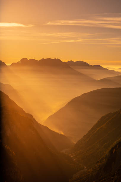 sunrays shining through mountain valley stock photo