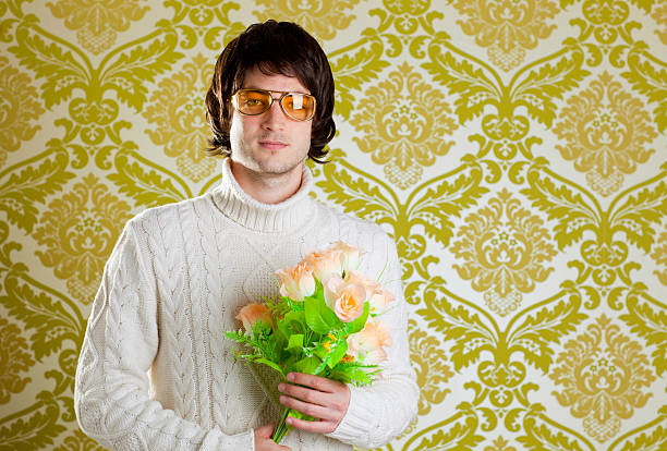 retro hip man holding valentines flowers retro hip young man vintage glasses holding valentines flowers bouquet on wallpaper nerd sweater stock pictures, royalty-free photos & images