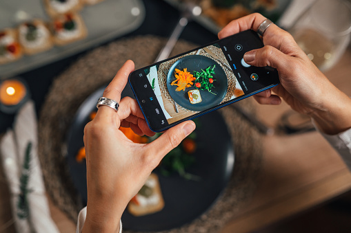 close up of woman photographing food with mobile phone