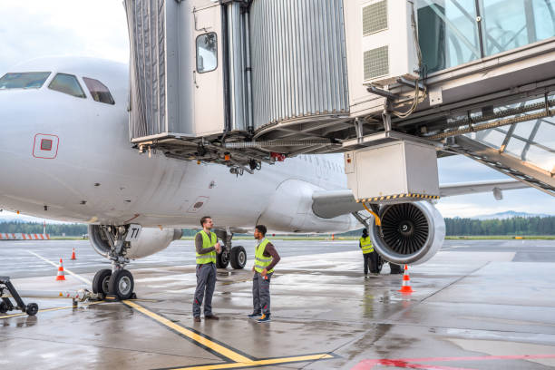 istock Mixed Race Male Air Controllers Standing Next To A Commercial Plane 1485015499